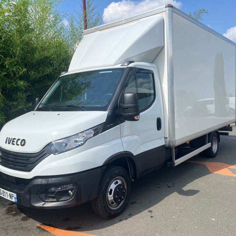 Camion de livraison blanc sur le parking.